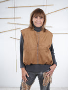 Camel­farbene Velours-Weste in Lederoptik mit komplett geschlossenem Reißverschluss und rundem Halsausschnitt.