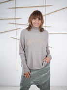 Taupefarbener Damen-Pullover mit beigem „New York“-Schriftzug, entspanntes Oversize-Design, Frontansicht.