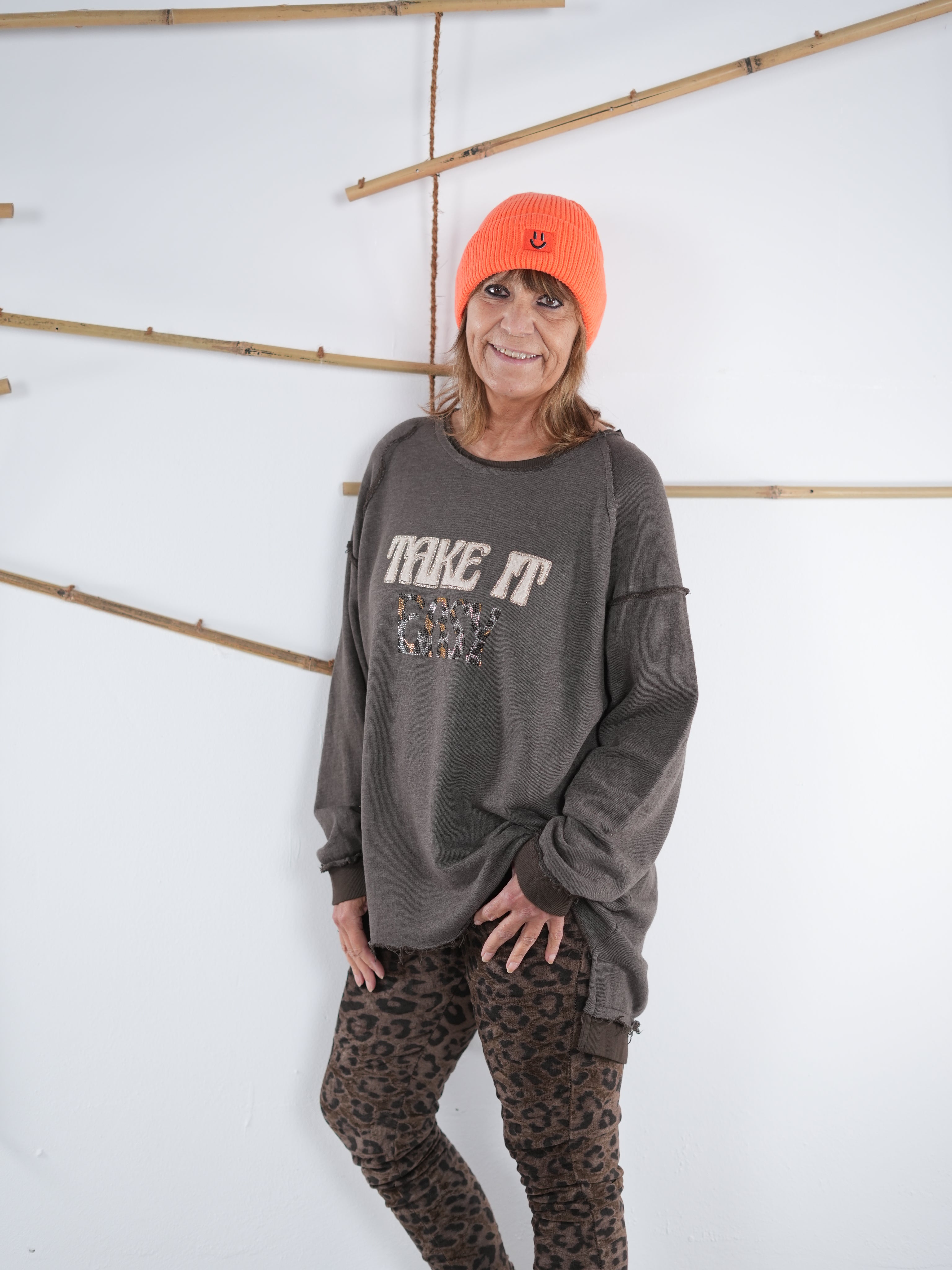 Seitliche Ansicht eines schokobraunen Vokuhila-Sweatshirts mit ausgefransten Nähten, kombiniert mit Leo-Leggings